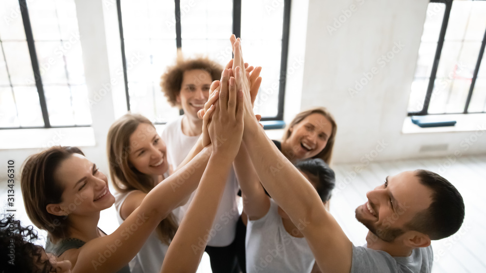 Close up diverse sporty people giving high five indoor Close up diverse sporty people giving high five indoor