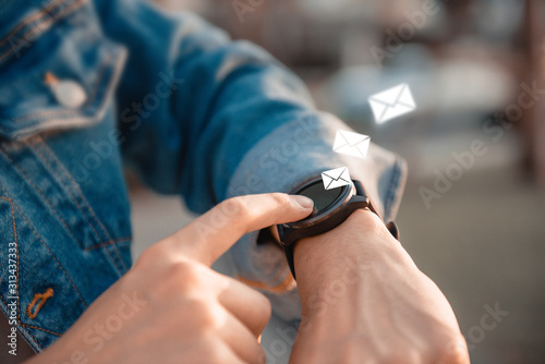 Closeup Man hand checking message and email in smart watch.