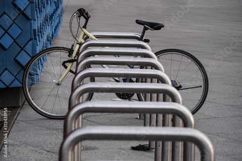 One old bike is fixed to a metal structure for Parking bicycles or scooters, environmental transport in the city. Moving by bike every day. bicycle at street parking outdoors