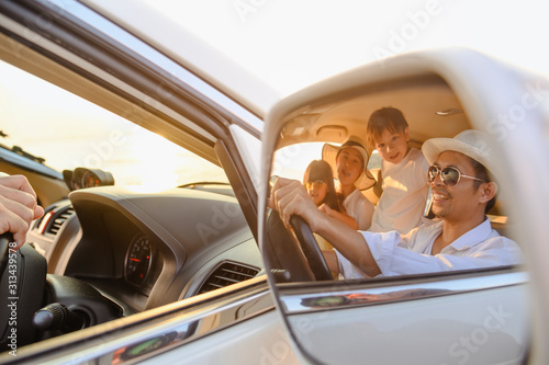 Family, travel, beach, relax, lifestyle, holiday concept. Close-up of images in the side mirror family who enjoy a picnic on the beach at sunset in holiday.