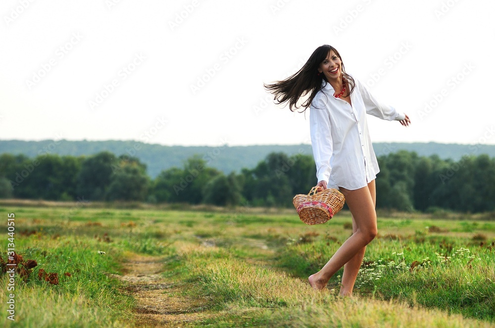 Girl dancing in field with basket in hands Girl dancing in field with basket in hands
