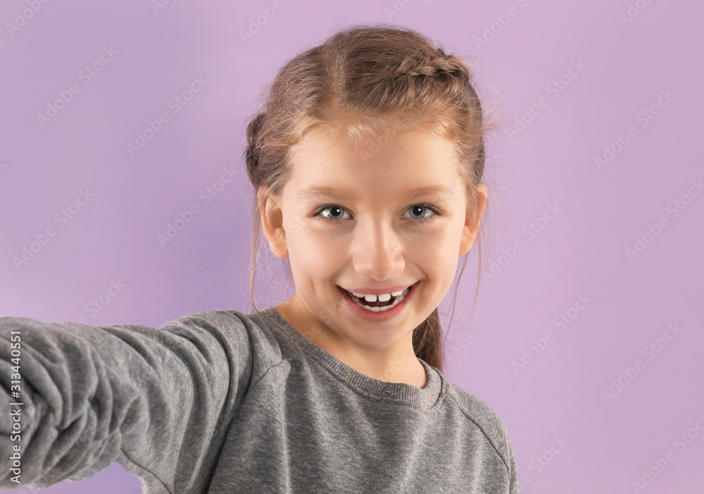Cute little blogger recording video on violet background Cute little blogger recording video on violet background