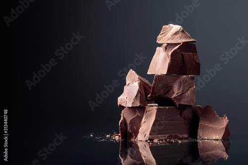 Pieces of dark chocolate on a dark background.