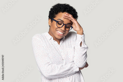 African woman lowers eyes down and looks embarrassed studio shot photo