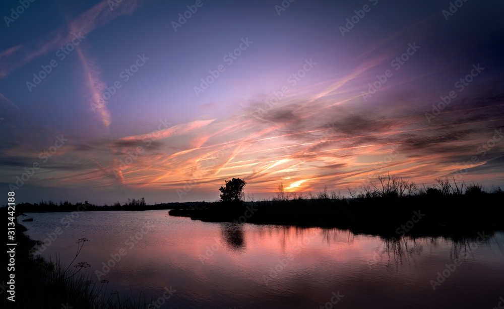 Spectacular sunrise reflected in the lakes at the wetlands of de Groote Peel, Limburg, the Netherlands. National Park on the border between Limburg and North Brabant, close to Meijel. Beautiful clouds