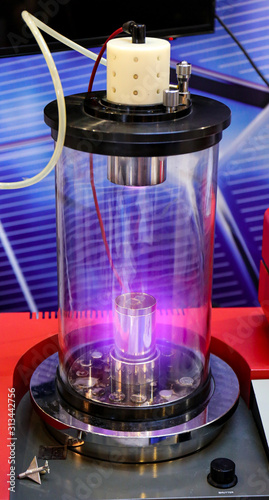 Mangetron sputtering with purple glowing plasma in vacuum glass tube photo