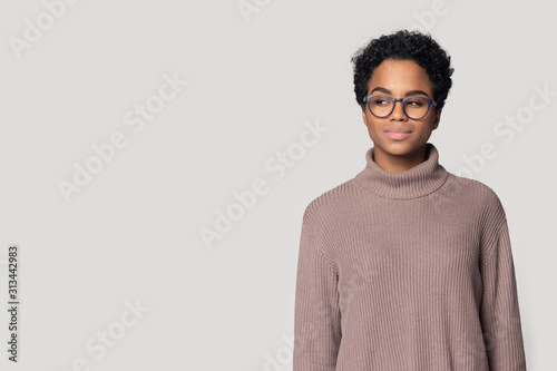 Woman pose aside on gray background looking sideways on copyspace photo