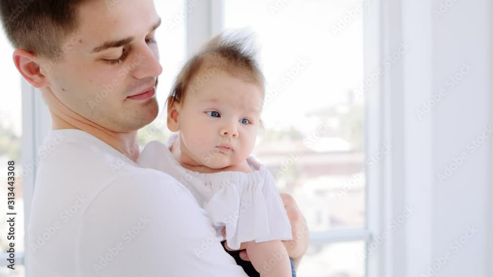 Loving young father holding infant at home Loving young father holding infant at home