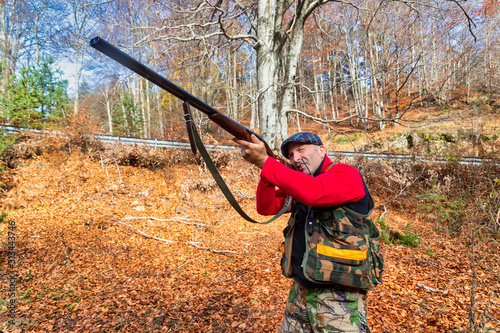 hunter with weapon chasing in the forest