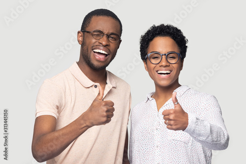 African couple in glasses showing thumbs up looking at camera photo