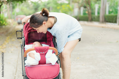 Mother with Baby in sitting stroller,family, child and parenthood concept.