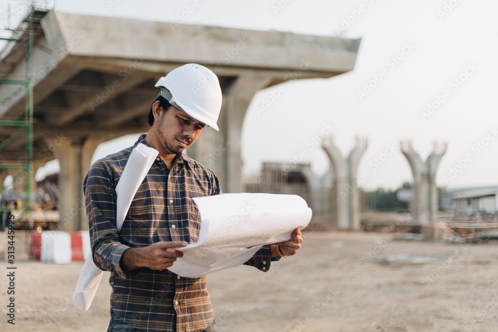 Asian Engineer Man Wearing Safety Helmet and Check Blueprint at Construction Site , Engineer Architect Construction Site Planning Concept Asian Engineer Man Wearing Safety Helmet and Check Blueprint at Construction Site , Engineer Architect Construction Site Planning Concept