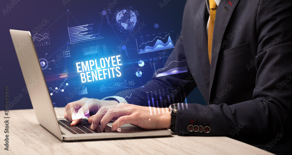 Businessman working on laptop with EMPLOYEE BENEFITS inscription, new business concept Businessman working on laptop with EMPLOYEE BENEFITS inscription, new business concept