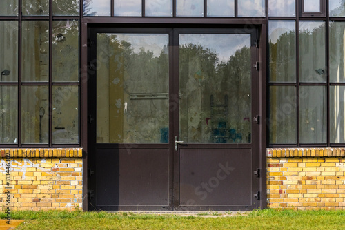 An old industrial facade with a glass front and a door, door with glass windows, yellow brick