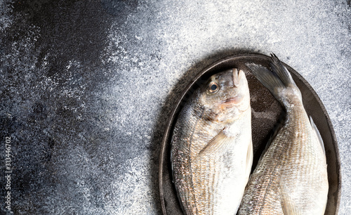 Fresh uncooked Dorado or sea bream fish in the pan