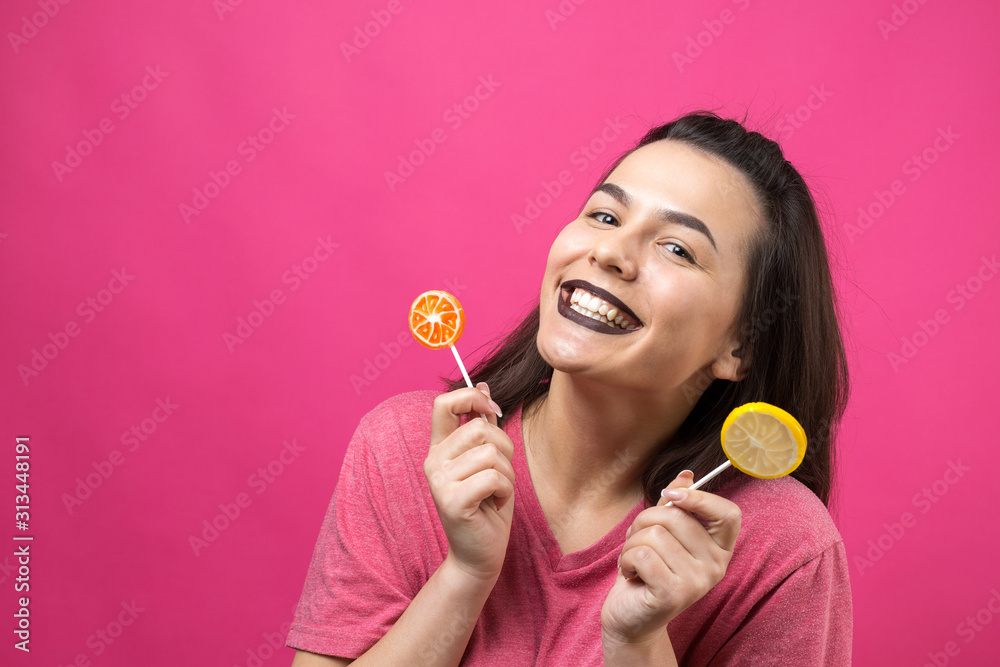 Portrait of lovely sweet beautiful cheerful woman with straight brown hair holding a lollipop near the eyes. Portrait of lovely sweet beautiful cheerful woman with straight brown hair holding a lollipop near the eyes.