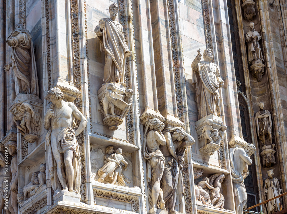 Fototapeta premium Milan Cathedral (Duomo di Milano) close-up, Milan, Italy. Detail of luxury facade with many marble statues and reliefs.