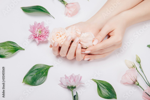 Concept beauty skin care. Beautiful stylish trendy female pink manicure with flower on background, top view