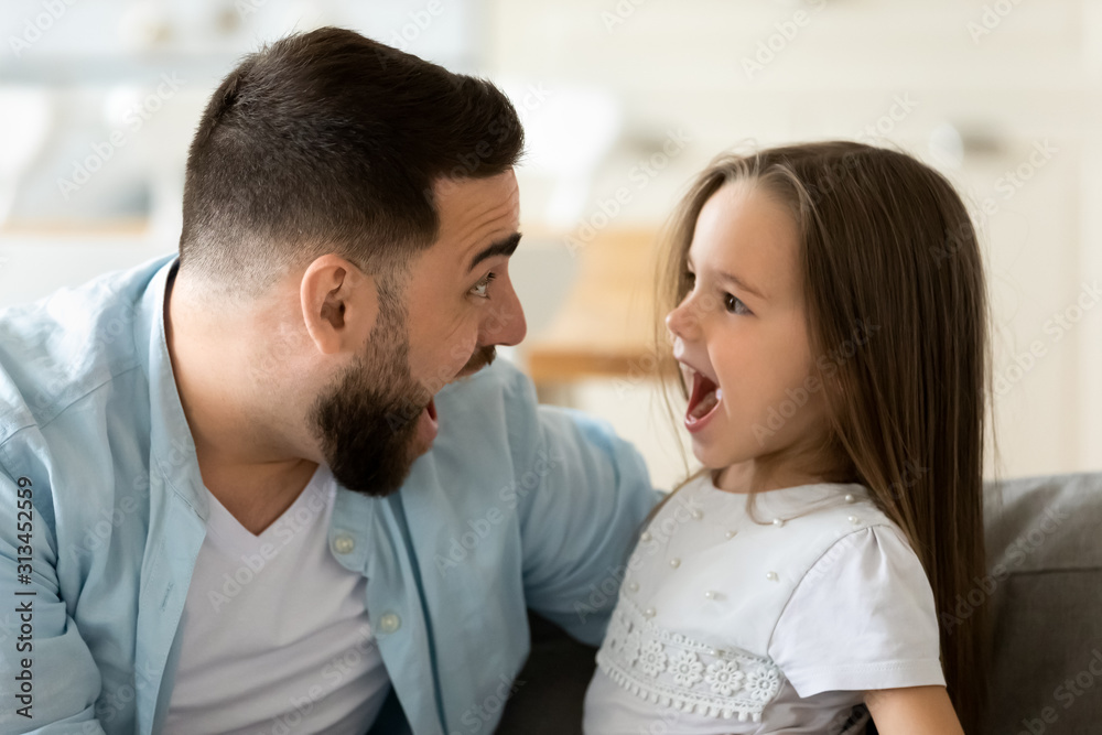 Funny dad and daughter looking at each other having fun Funny dad and daughter looking at each other having fun