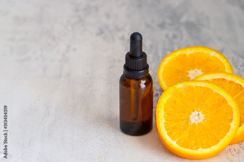 Fresh orange fruit and orange essential oil on concrete background. Natural medicine and Ayurvedic treatment. Fresh orange fruit and orange essential oil on concrete background. Natural medicine and Ayurvedic treatment.