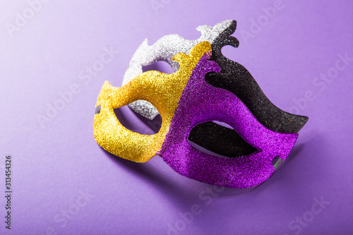 A festive, colorful group of mardi gras or carnivale mask on a purple background. Venetian masks. photo