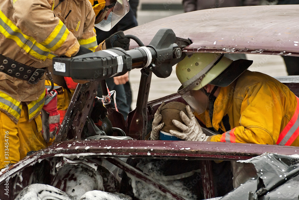 Demonstration of rescue work. Firefighters break into a car after an accident. Rescue team retrieve the victim from the burned car. Training firefighters. Demonstration of rescue work. Firefighters break into a car after an accident. Rescue team retrieve the victim from the burned car. Training firefighters.