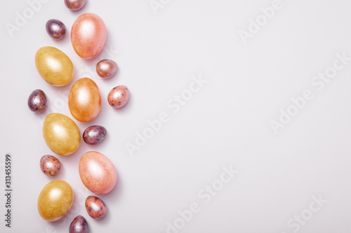 Layout of Easter eggs painted in pastel colors on a white background, top-down view