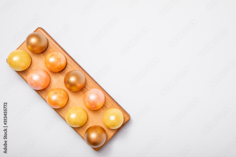 Top-down view of Gold colored Easter eggs with copy space for text on white background, flat lay design Top-down view of Gold colored Easter eggs with copy space for text on white background, flat lay design