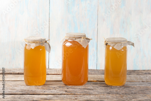 Kombucha tea in glass canister on wooden background