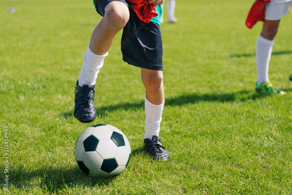 Young Soccer Player with Classic White and Black Ball on the Green Grass Soccer Pitch Young Soccer Player with Classic White and Black Ball on the Green Grass Soccer Pitch