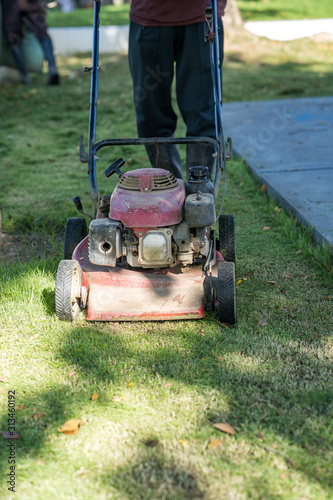  123RF.com Gardener mowing green grass lawn with push mower 