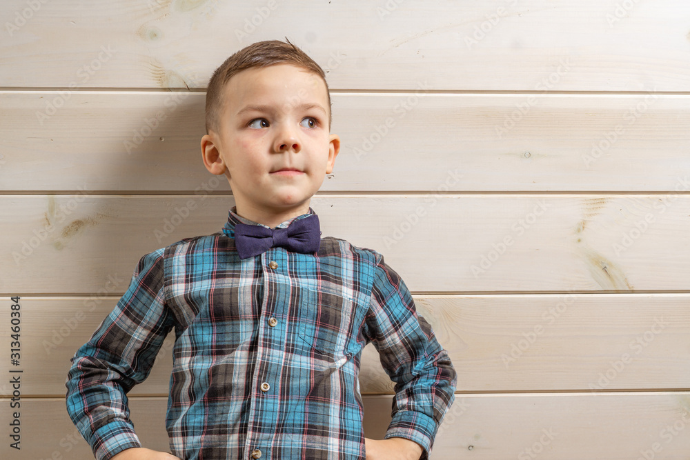 Ταπετσαρία A 4 years old boy in a blue clerical shirt is crying on a light wooden background