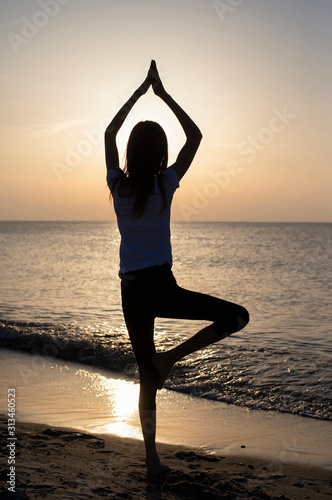junges Mädchen macht Yoga am Meer