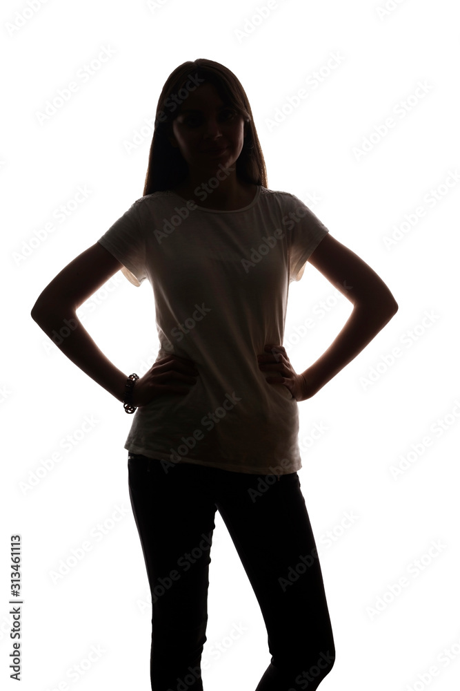 Young girl stands and holds hands on belt - silhouette
