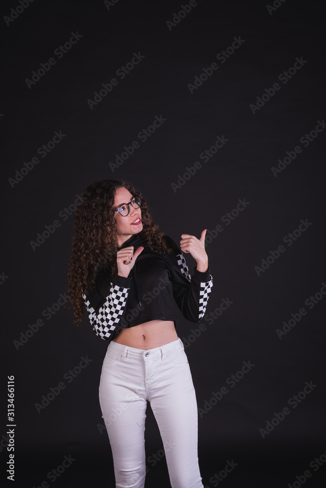 Young girl model posing with cute racing sweater in black background