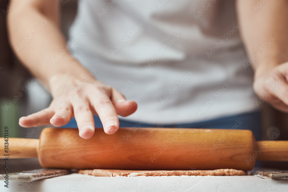 Female hands rolling dough on the table, closeup. Woman making dough for baking in kitchen Female hands rolling dough on the table, closeup. Woman making dough for baking in kitchen
