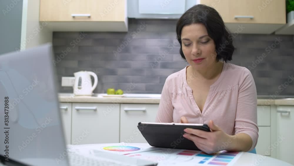 Middle-aged freelancer working on tablet at home, female designer working online Middle-aged freelancer working on tablet at home, female designer working online