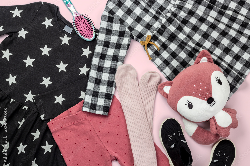 Fototapeta premium Girl's clothing and accessories flat lay on bright pink background