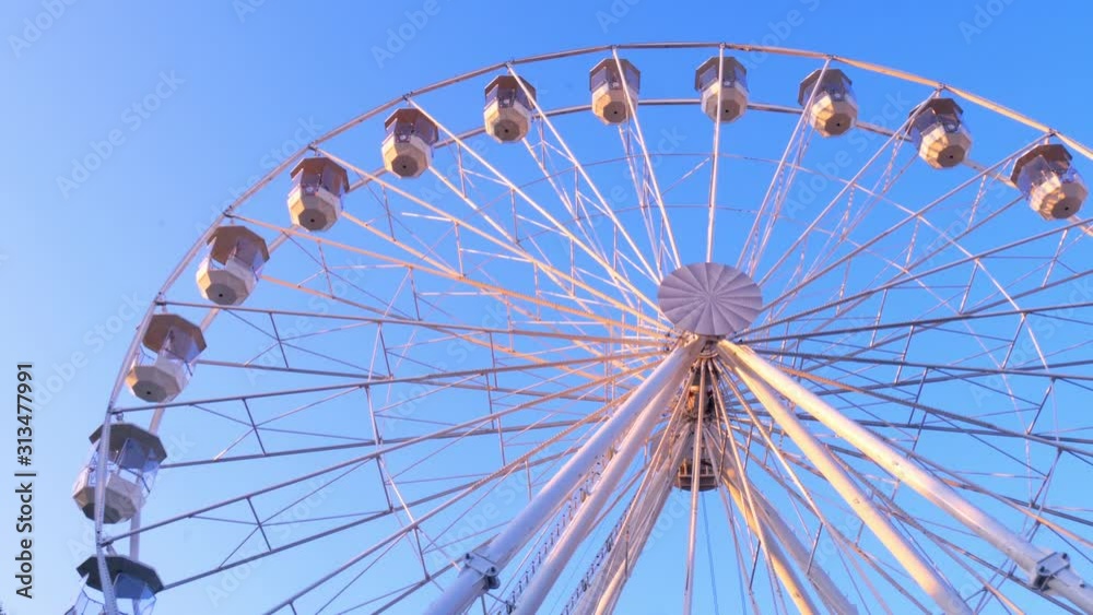 Closeup view on a moving ferris wheel on sunny autumn day. Closeup view on a moving ferris wheel on sunny autumn day.
