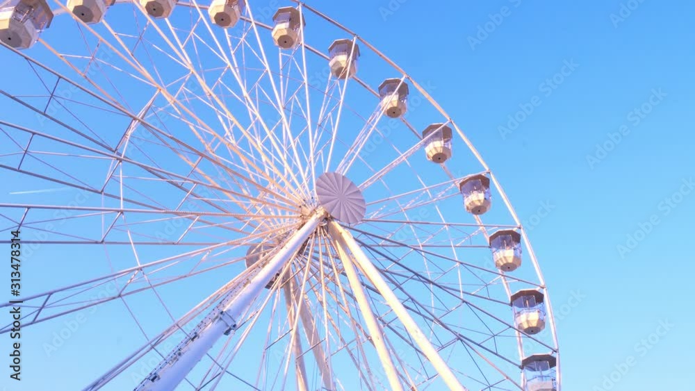 Closeup view on a moving ferris wheel on sunny autumn day. Closeup view on a moving ferris wheel on sunny autumn day.
