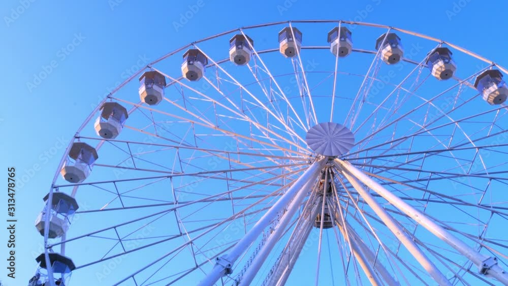 Closeup view on a moving ferris wheel on sunny autumn day. Closeup view on a moving ferris wheel on sunny autumn day.