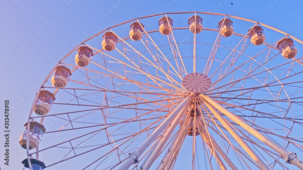 Closeup view on a moving ferris wheel on sunny autumn day. Closeup view on a moving ferris wheel on sunny autumn day.