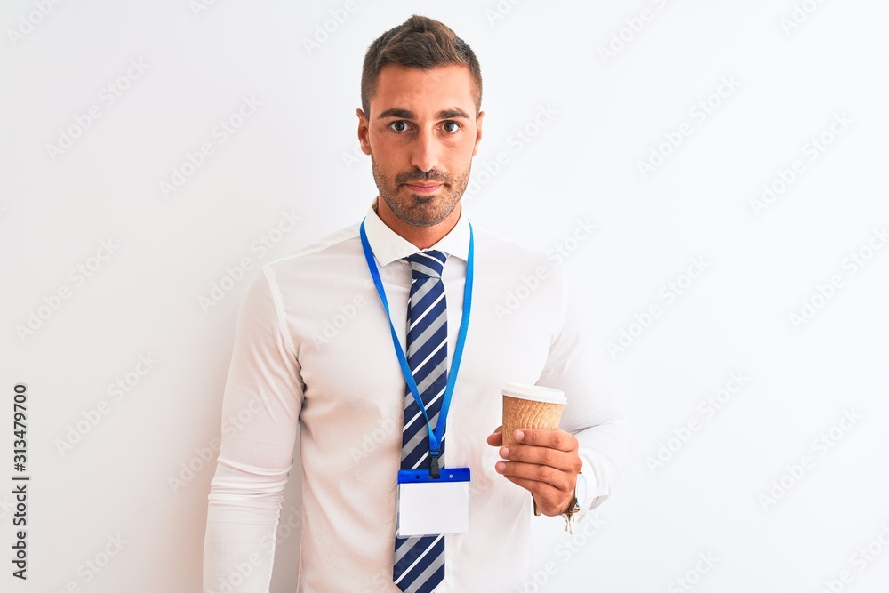 Young handsome business man wearing id pass and drinking coffee over isolated background with a confident expression on smart face thinking serious Young handsome business man wearing id pass and drinking coffee over isolated background with a confident expression on smart face thinking serious
