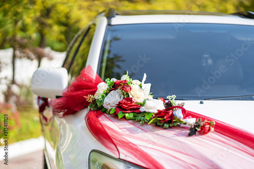 White wedding car decorated with fresh flowers. Wedding decorations.