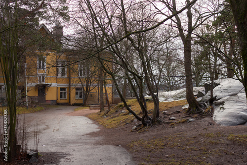 A large stone in the courtyard of a house on the Merikannontie street in Helsinki in Finland on a late autumn day. Stones of different sizes, small and very large, are characteristic of  landscapes