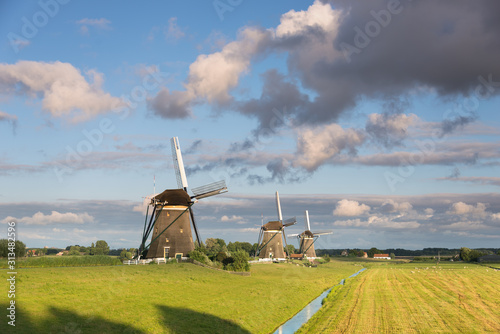 Three windmills in the countryside in the Netherlands photo
