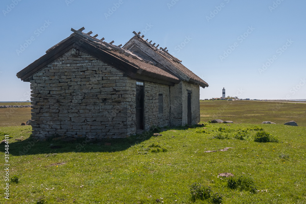 An old stone house stands on a green meadow. Oland, Sweden