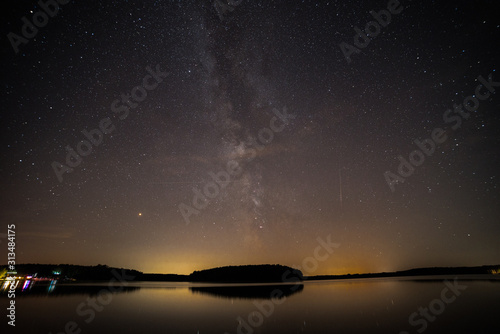 starry sky with milky way and reflections in a lake