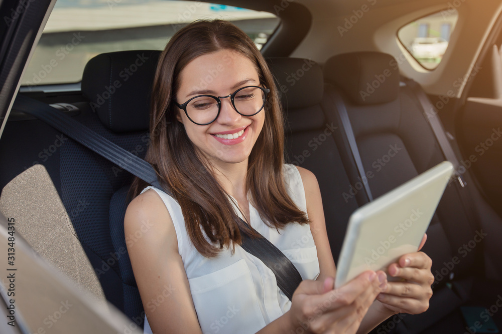 Young woman with gadget smartphone sitting in modern car Young woman with gadget smartphone sitting in modern car