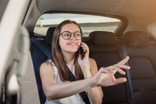 Young woman with gadget smartphone sitting in modern car